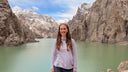 Woman standing in front of a lake with mountains in the background